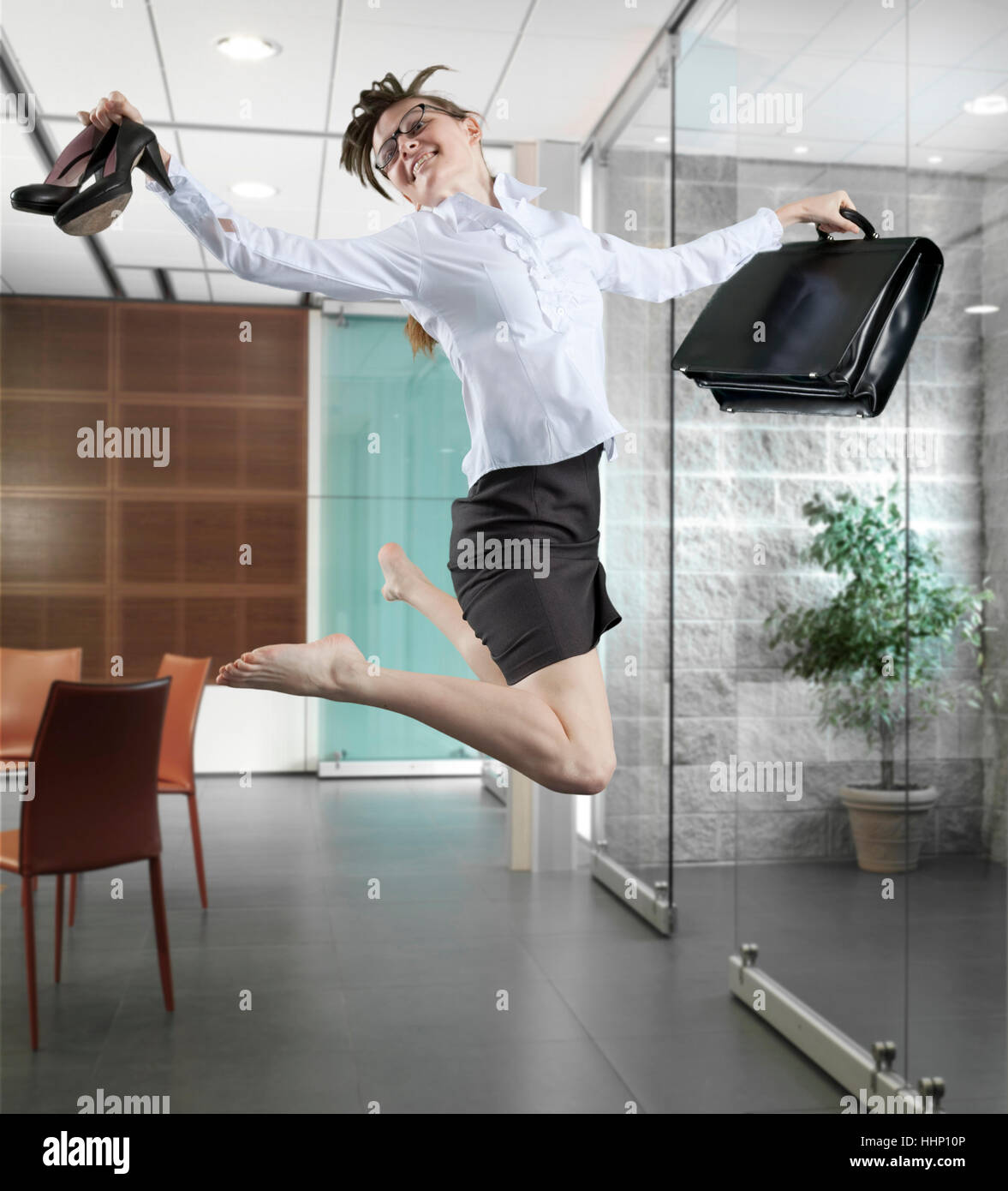 Imprenditrice caucasica jumping in office Foto Stock