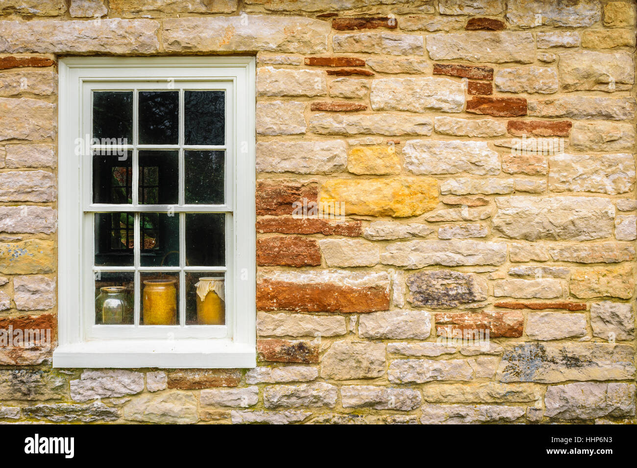 Finestra che mostra ceramica in un muro di pietra. Foto Stock