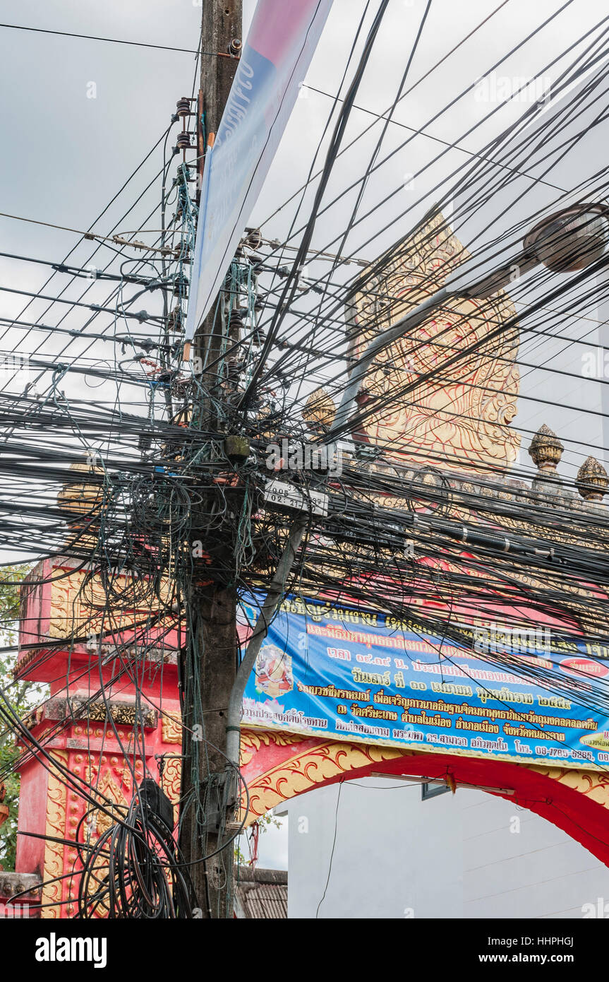 Incredibile groviglio di fili elettrici fuori un polo elettrico nel centro di Nong Khai nel nordest della Thailandia, vicino al confine del Laos. Foto Stock