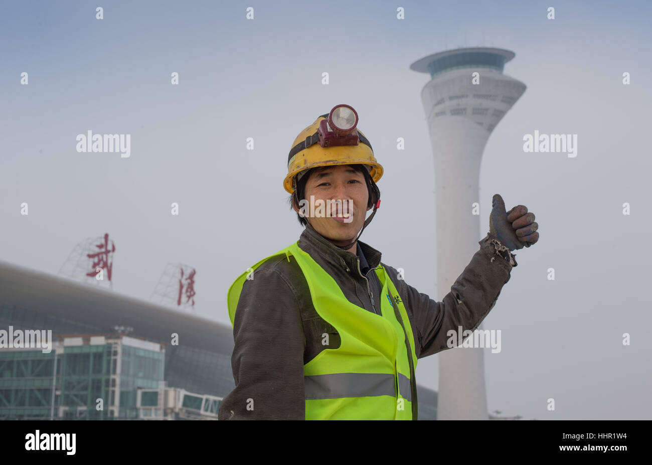 (170120)-- WUHAN, Gennaio 20, 2017 (Xinhua) -- Zang Haizhou, una installazione meccanica ed elettrica lavoratore, pone per le foto con il T3 terminale sito in costruzione presso l'Aeroporto Tianhe a Wuhan, capitale della Cina centrale della provincia di Hubei, Gennaio 19, 2017. Il terminale, con l'installazione meccanica ed elettrica principalmente completa, saranno messi in uso entro il prossimo mese di marzo. I lavoratori di questo progetto il giovedì ha posato per le foto con la costruzione del sito prima di tornare a casa per il ricongiungimento familiare. (Xinhua/Ke Hao) (xzy) Foto Stock