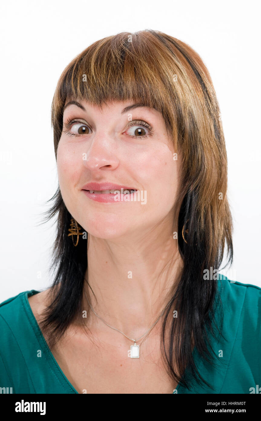 Testa ritratto di una giovane donna bruna contro uno sfondo bianco dubiously scary guardando nella telecamera. Foto Stock