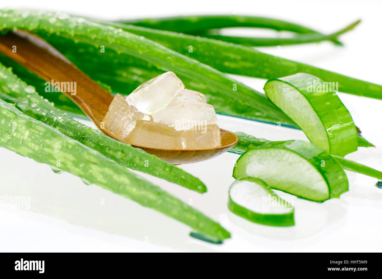 Cucchiaio di aloe vera el tagliato nel cubo. Aloe vera gel in cucchiaio di legno con Aloe Vera foglie su sfondo bianco. Aloe vera gel quasi uso alimentare, medic Foto Stock