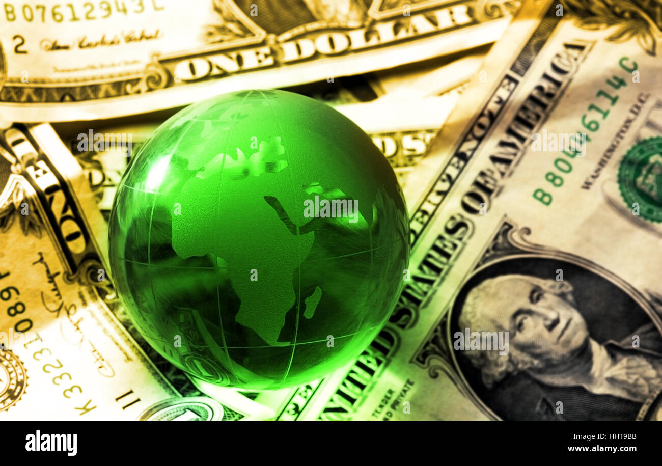 Verde globo di cristallo su fatture del dollaro il concetto di globalizzazione luce calda Foto Stock