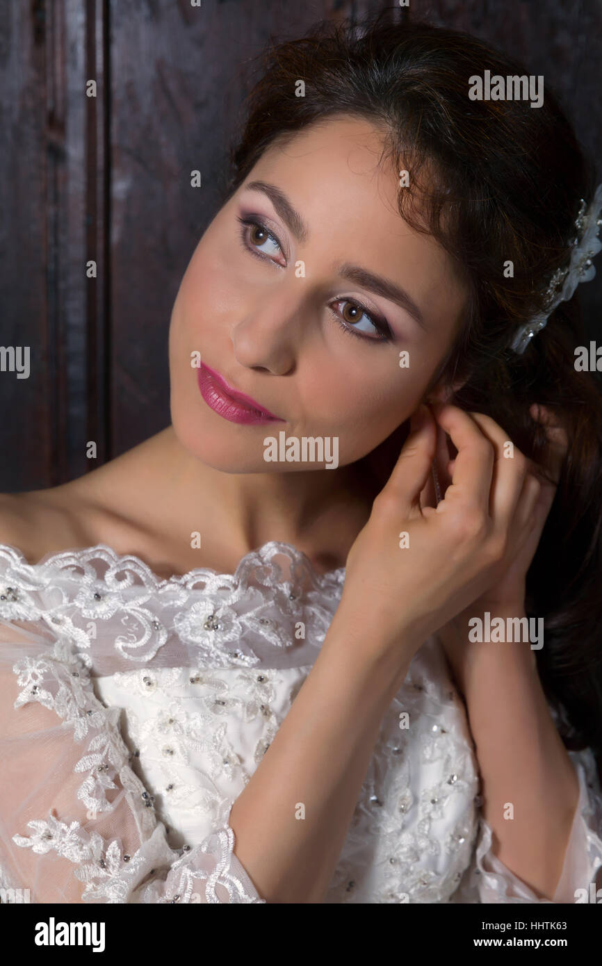 Bellissime brunette sposa in posa in interni nel suo abito da sposa Foto Stock