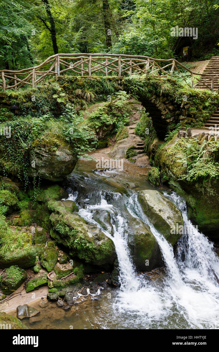 Ponte sopra la cascata Schiessentumpel, vicino Waldbillig, Mullerthal Trail, Lussemburgo. Foto Stock