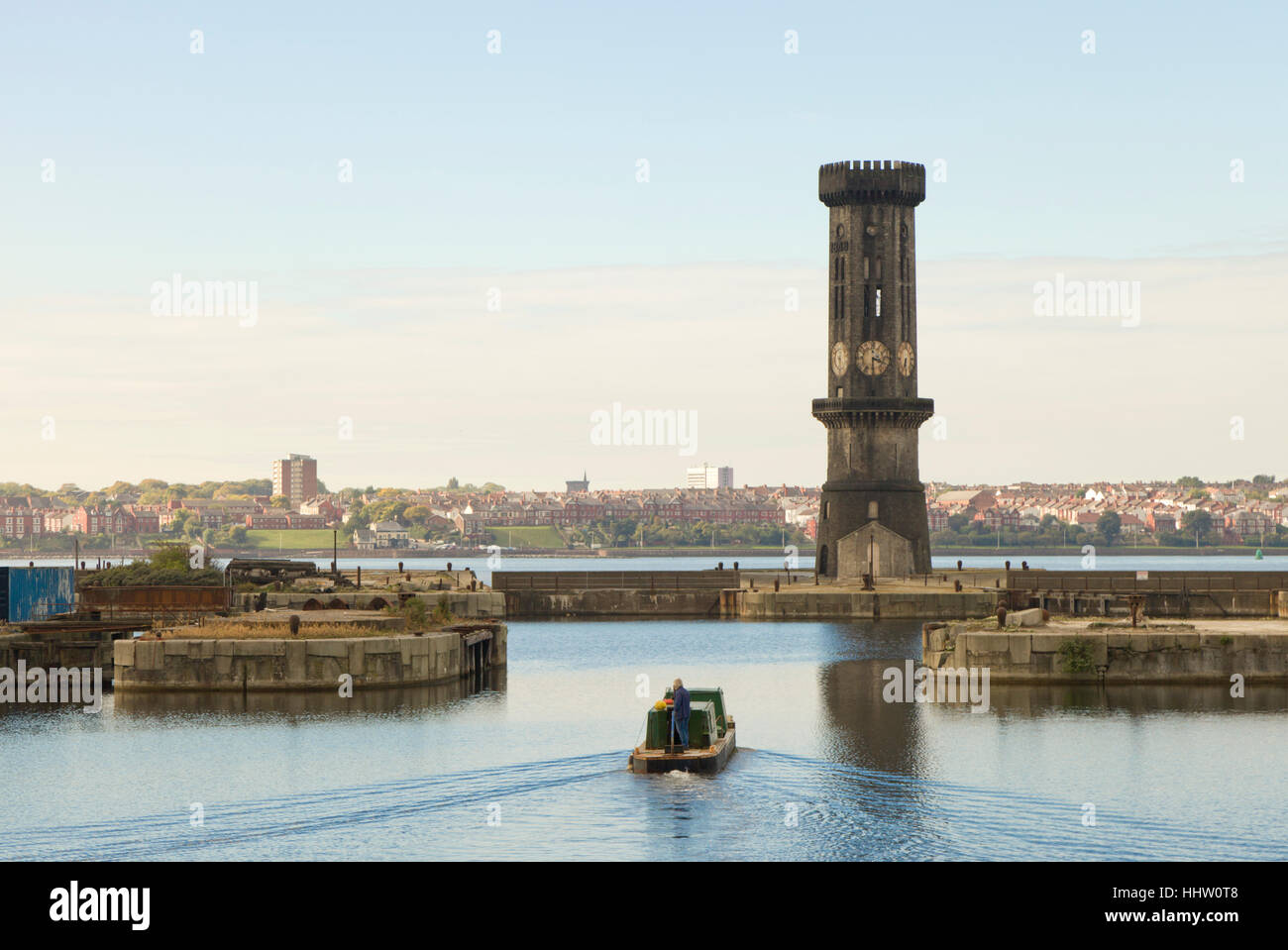 Una chiatta lascia Salisbury Dock dominato dalla gotica Torre di Victoria, una Grade II Revival gotico di clock tower, Liverpool Foto Stock