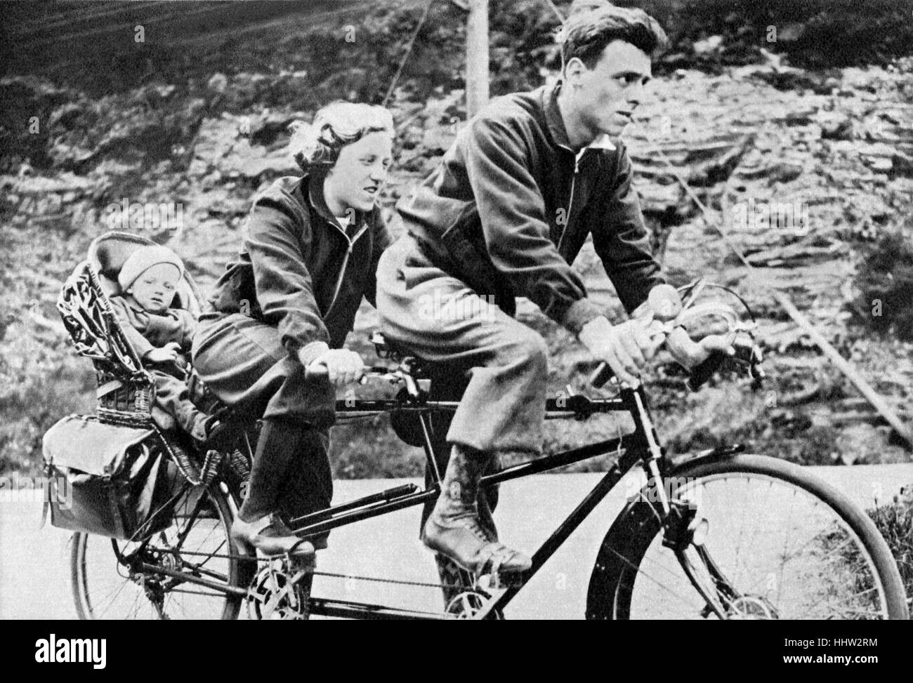 Famiglia giovane in sella ad una bicicletta in tandem, 1930s Foto Stock