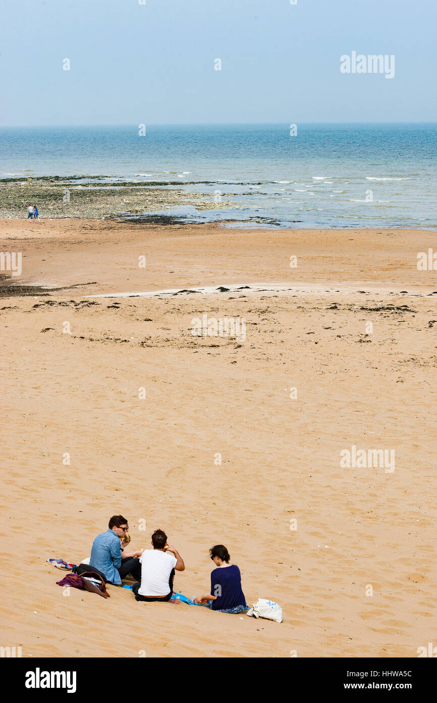 Il Kingsgate Bay, Margate, Kent. Gruppo di amici gustando un picnic sulla spiaggia al Kingsgate Bay. Foto Stock