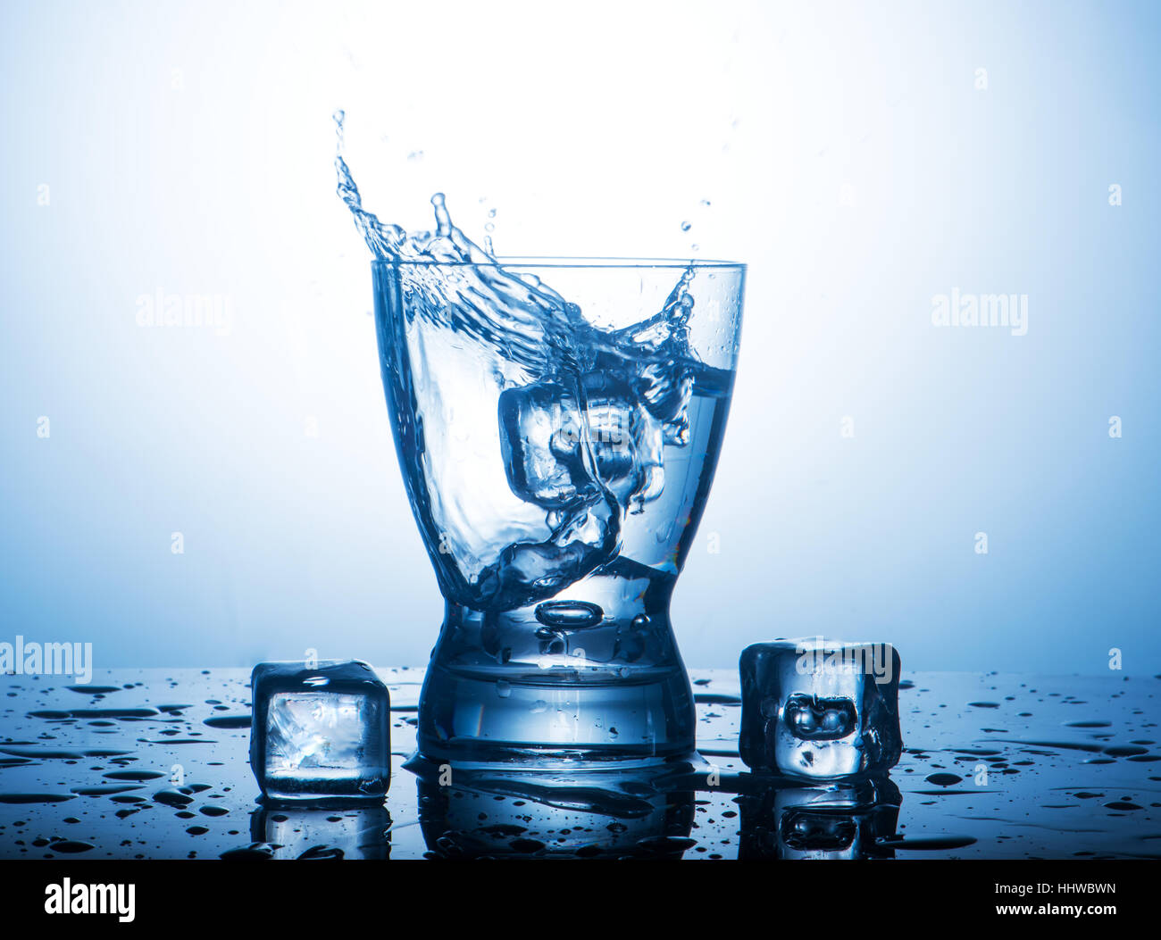 Splash acqua in un bicchiere e pezzi di ghiaccio Foto Stock