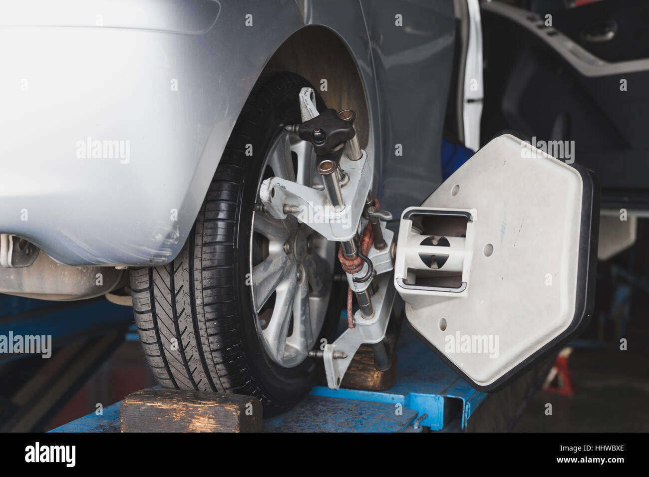 Auto su piedistallo con sensori sulle ruote per allineamento delle ruote controllo campanatura in officina della stazione di servizio Foto Stock