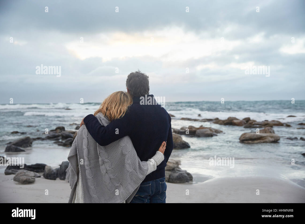 Serena affettuosa giovane costeggiata sulla spiaggia invernale guardando ocean Foto Stock