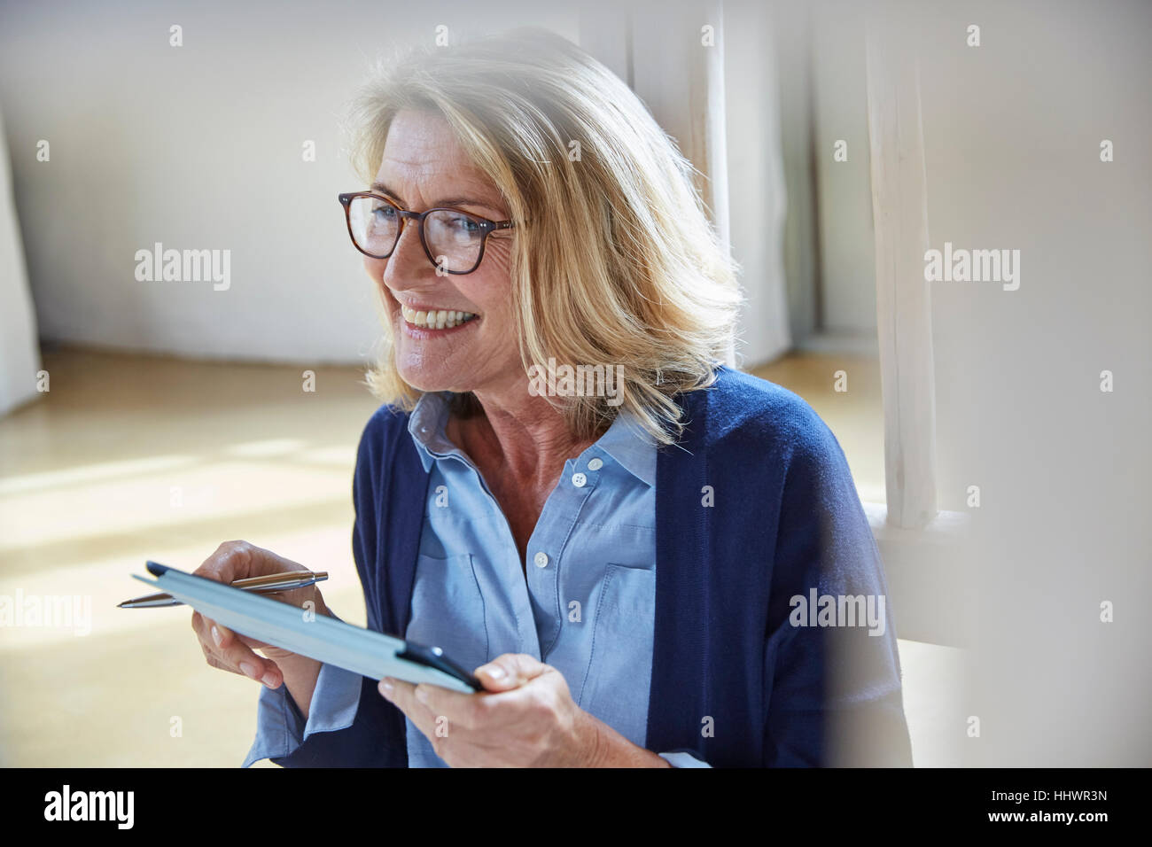 Sorridente donna senior con tavoletta digitale Foto Stock