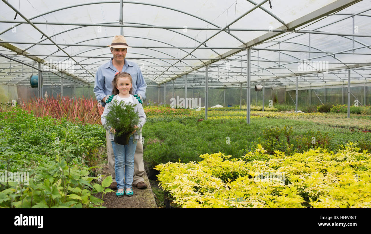 Giardiniere e grandddaughter nella serra azienda grande pianta in vaso Foto Stock