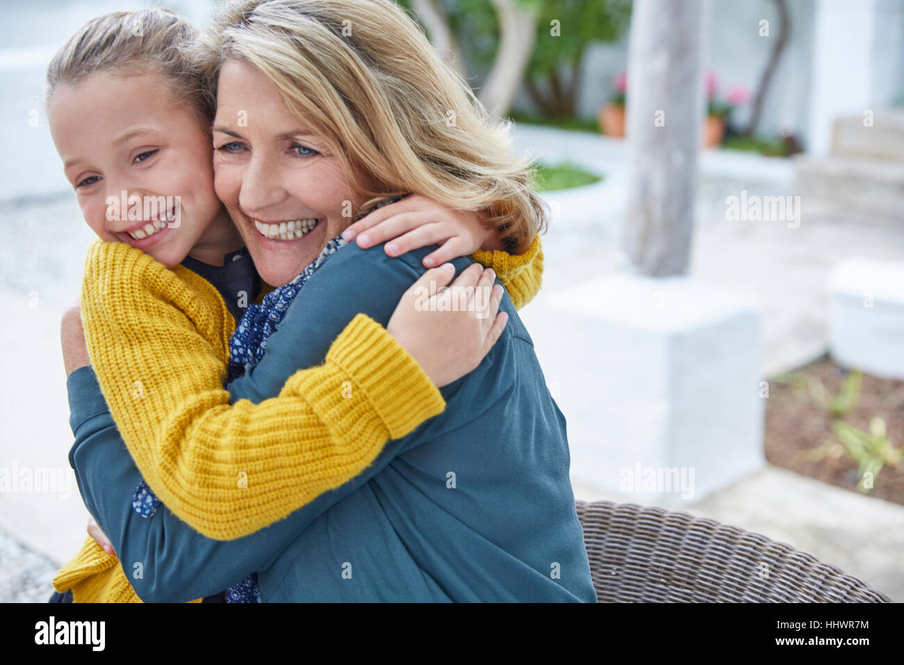 Entusiasta la nonna e la nipote abbracciando sul patio Foto Stock