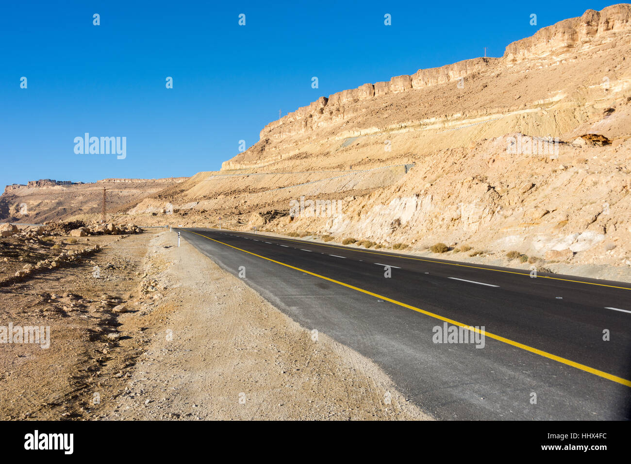 Strade del deserto che conduce al cratere di Ramon (Makhtesh) di Mizpe Ramon nel sud di Israele nel deserto del Negev Foto Stock