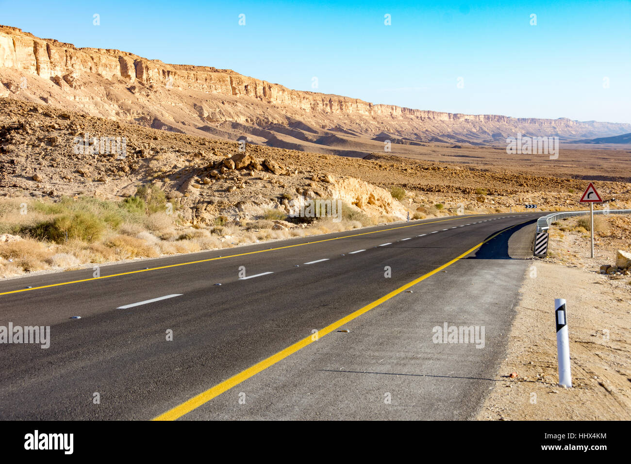 Strade del deserto che conduce al cratere di Ramon (Makhtesh) di Mizpe Ramon nel sud di Israele nel deserto del Negev Foto Stock