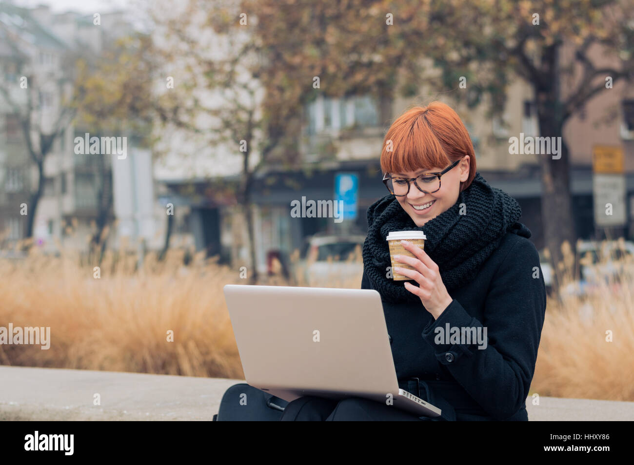 Business donna lavora sul computer esterno Foto Stock