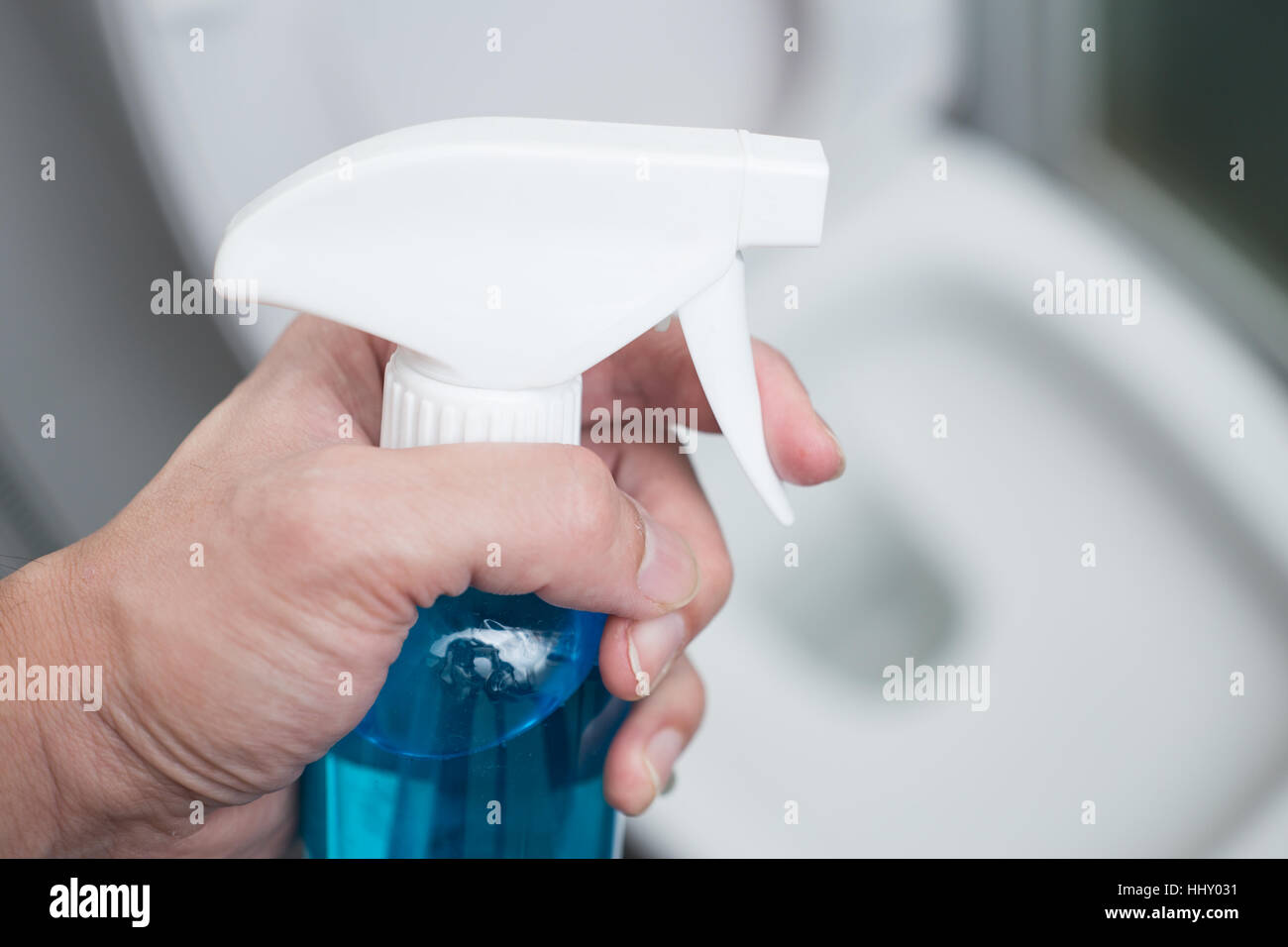 Spray a mano con detergente per pulire i sedili di gabinetto o bagno sfondo. Foto Stock