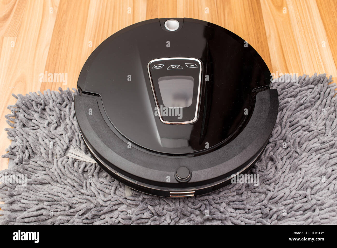 Robotica aspirapolvere su legno parquet, Smart vuoto, nuova tecnologia di automatizzare i lavori di casa - Pulizia sul tappeto. Foto Stock