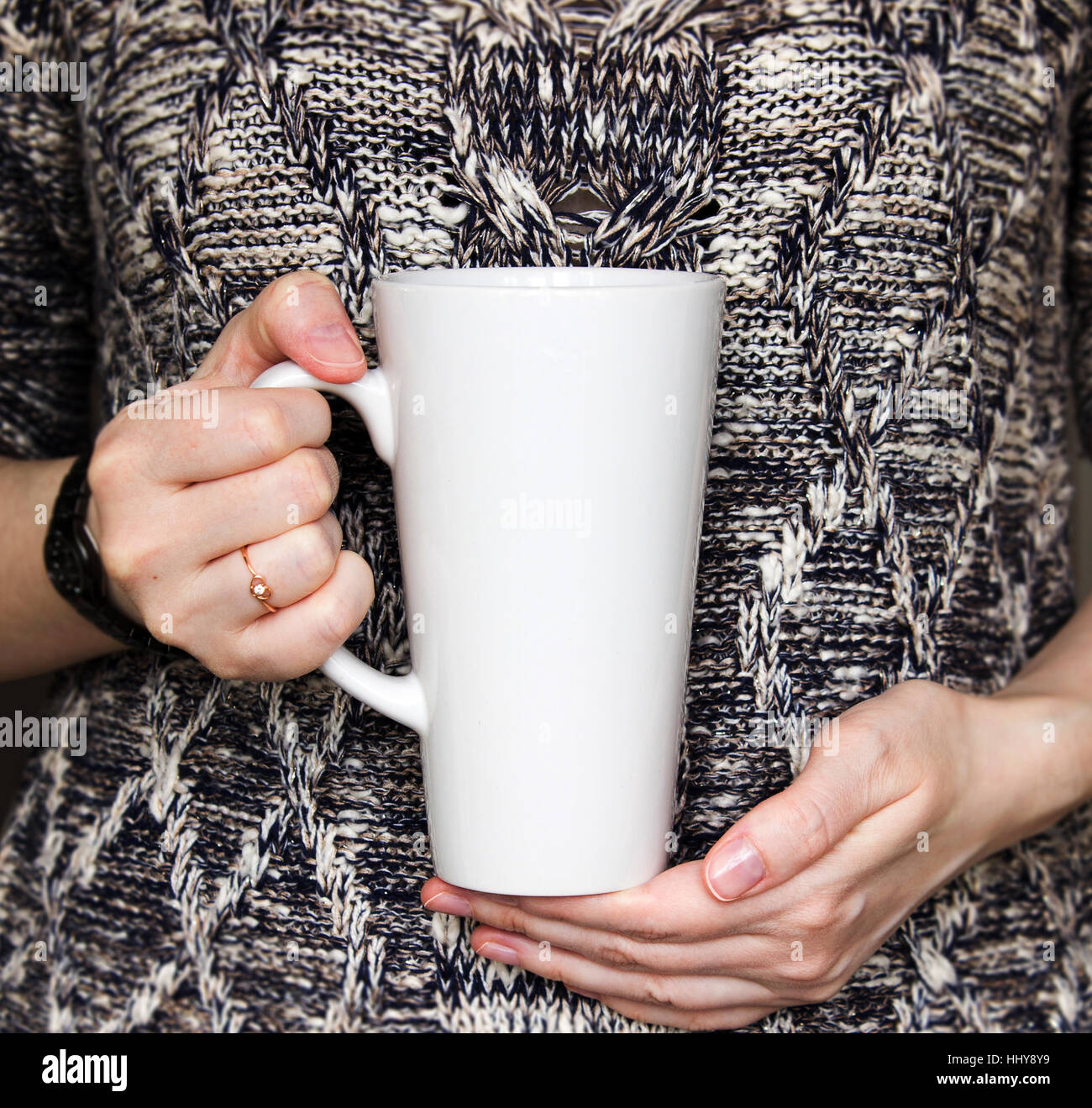 La ragazza è in possesso di bianco latte Mug in mani. Womans dono. Mockup per disegni e modelli. Foto Stock