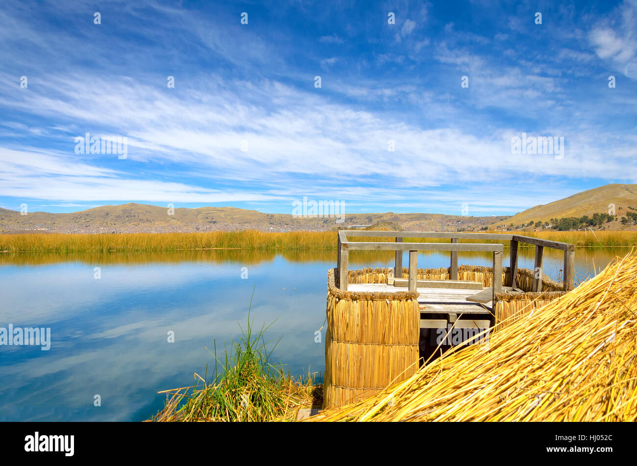 Punto di vista su uno degli Uros isole galleggianti sul lago Titicaca in Perù con Puno visibile in background Foto Stock