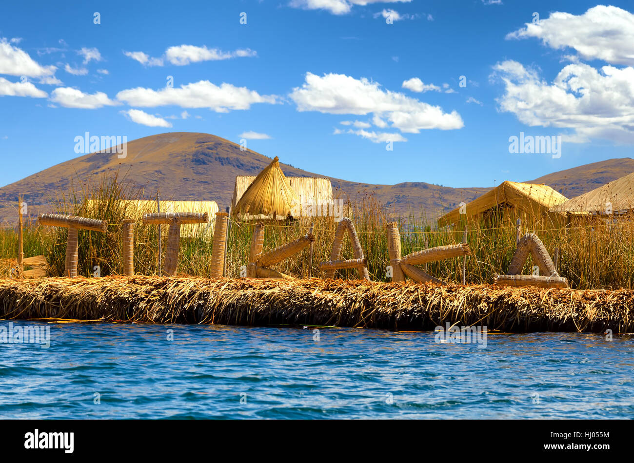 Manmade isola galleggiante con un segno di ortografia Titikaka fuori sul lago Titicaca in Perù Foto Stock