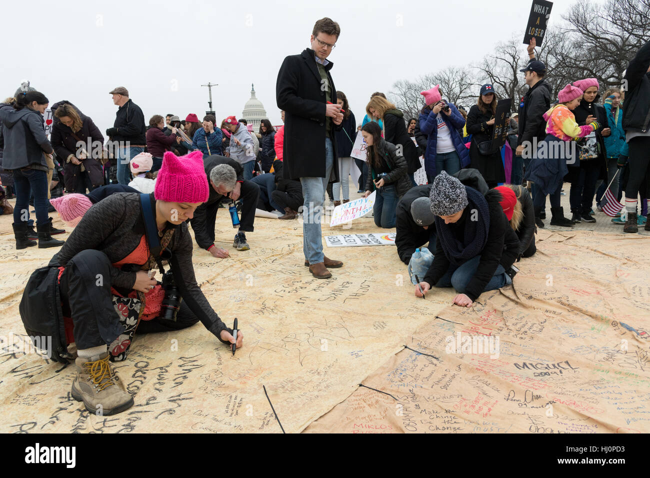 Washington, Stati Uniti d'America. Xxi gen, 2017.manifestanti firmare una petizione gigante durante le donne del marzo su Washington in segno di protesta al presidente Donald Trump in Washington, DC. Più di 500.000 persone stipate National Mall in una pacifica e il festival di rally in un rimprovero del nuovo presidente. Credito: Planetpix/Alamy Live News Foto Stock