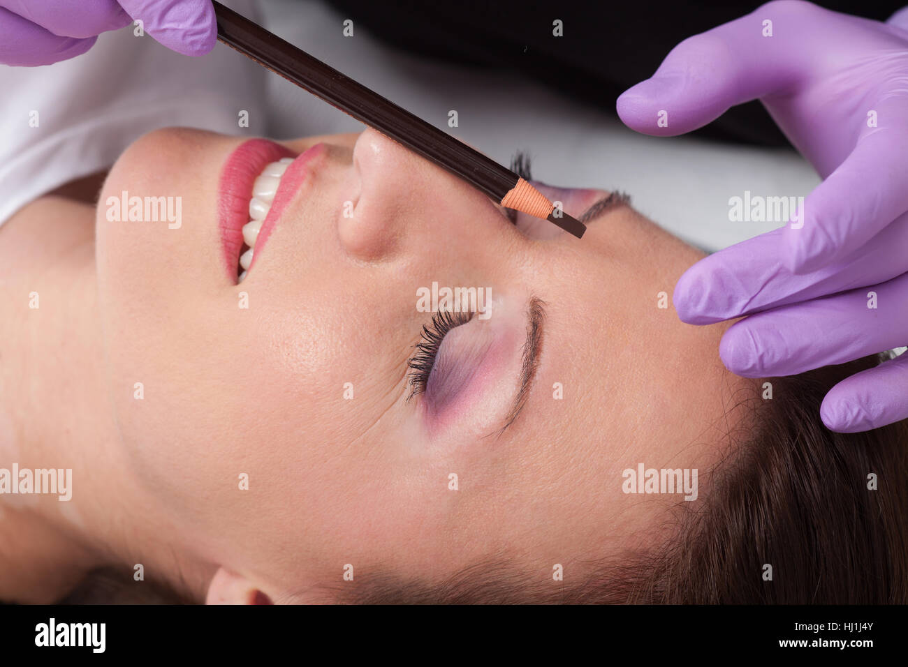 Cosmetologo preparazione di una donna per le sopracciglia permanente make up Foto Stock