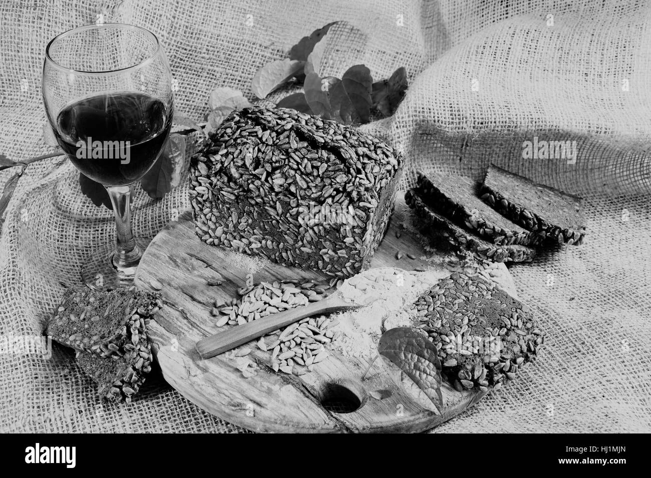 Decorazione con pane nero e vino rosso sul round tagliere in legno Foto Stock