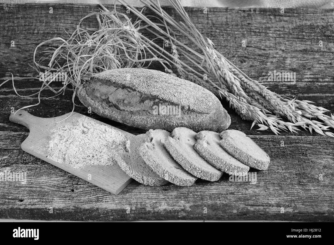 Decorazione con pane di segale, le erbe aromatiche essiccate e farina su una base di legno Foto Stock