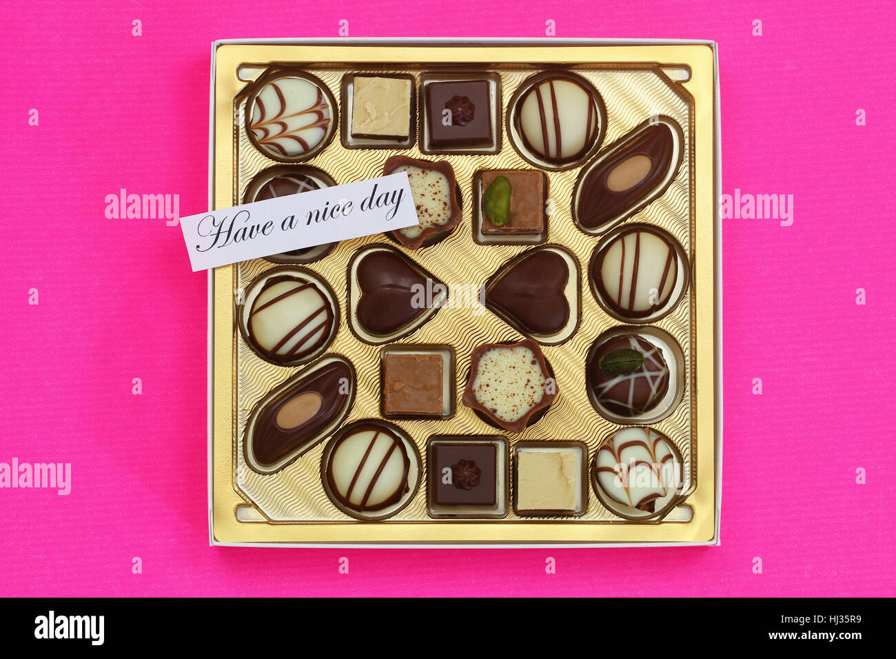 Hanno un bel giorno della carta con una scatola di cioccolatini assortiti su sfondo rosa Foto Stock