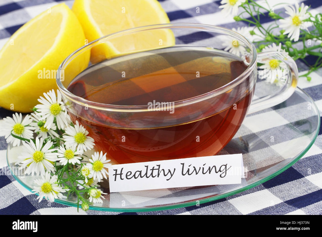 Uno stile di vita sano card con tazza di tè alle erbe, fiori di camomilla e limone Foto Stock