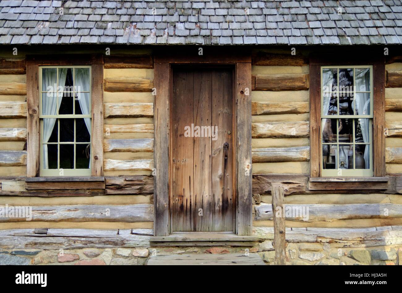 Pioneer tradizionale log cabin. esterna della porta anteriore della parete e del centro storico di 1800s style pioneer home. Foto Stock