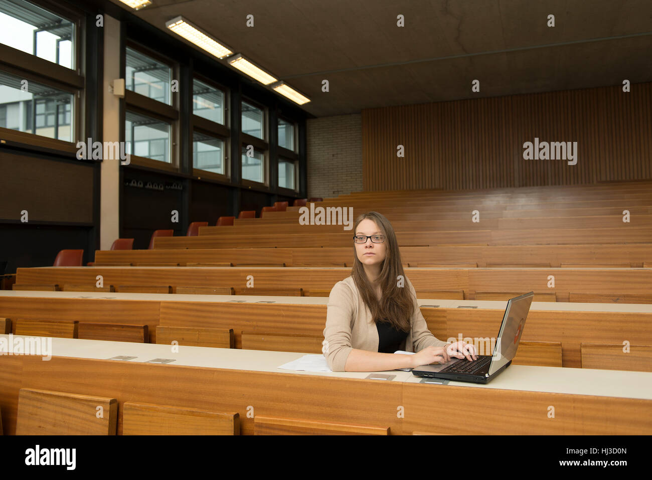 Studente con il computer portatile in auditorium Foto Stock