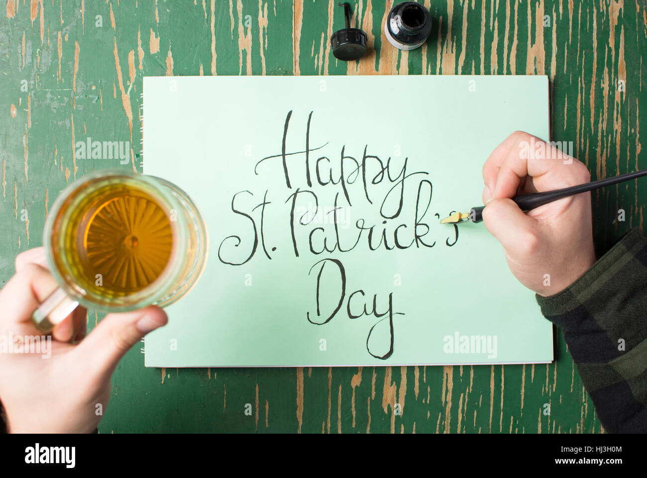L'uomo con una birra con felice St Patrick giorno scheda di calligrafia Foto Stock