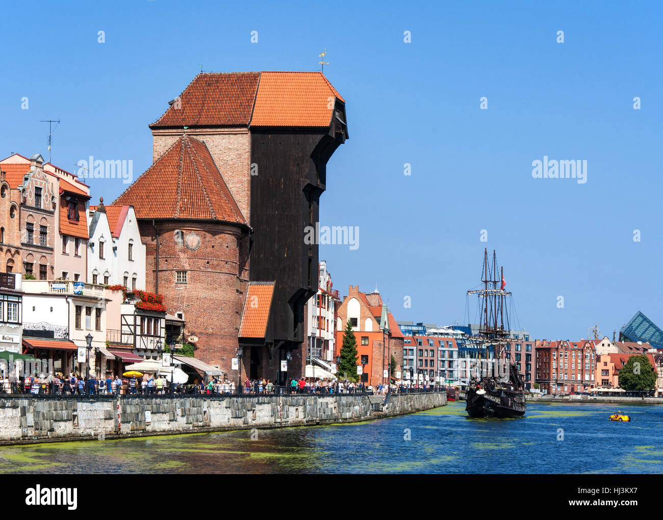 Vecchia città medievale con la porta di legno gru, la più antica in Europa, Motlava river, turistico la nave dei pirati e la folla di gente che cammina Foto Stock