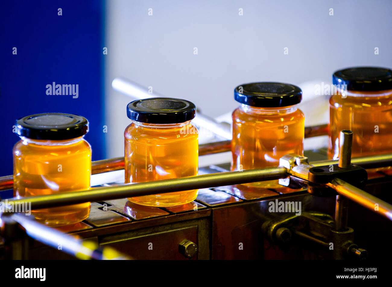 Produzione di miele naturale e di imbottigliamento in vasetti per la vendita al dettaglio. Foto Stock