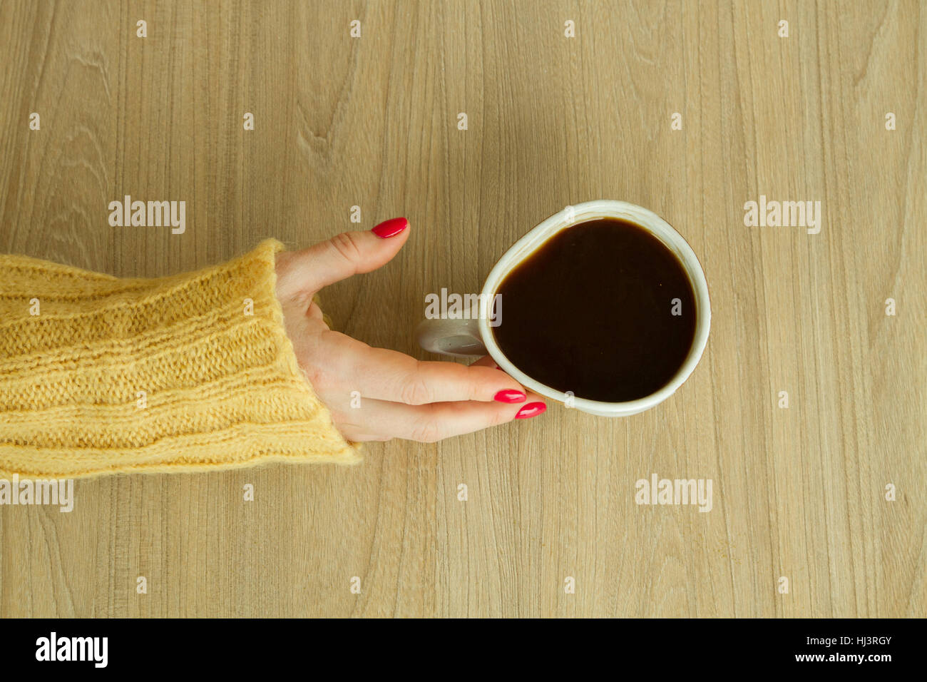 Donna con mano manicure rosso sta per prendere una tazza di caffè Foto Stock