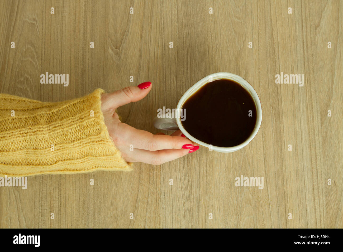 Donna con mano manicure rosso sta per prendere una tazza di caffè Foto Stock