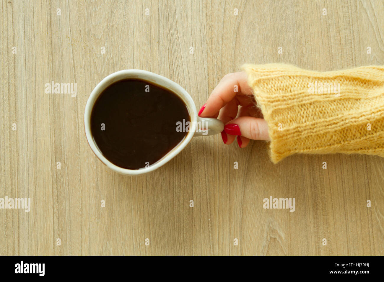 Donna con mano manicure rosso sta per prendere una tazza di caffè Foto Stock