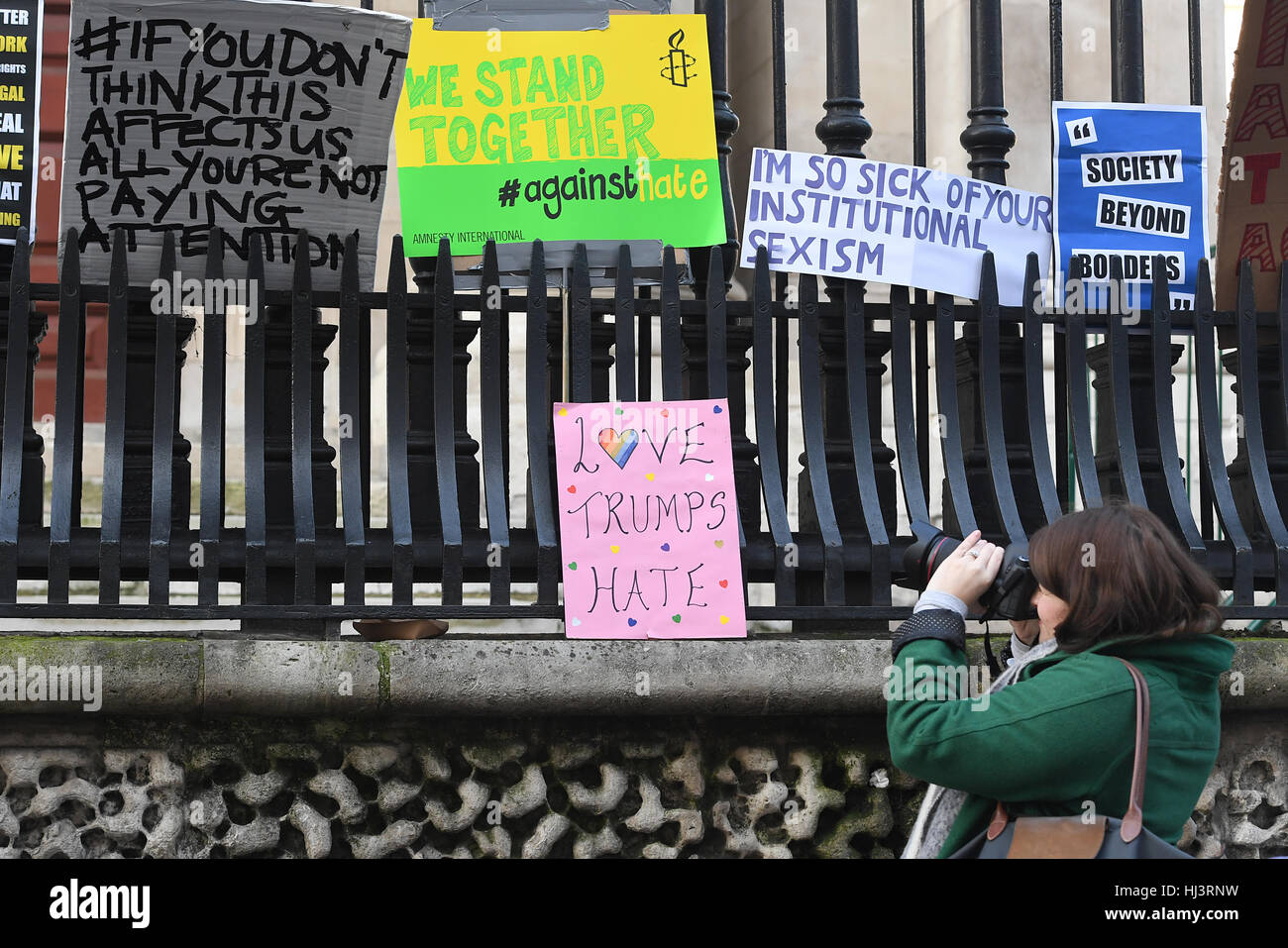 Una donna scatta una foto dei banner di protesta lasciati a Duncannon Street, Londra, dopo una marcia di sabato per promuovere i diritti delle donne sulla scia del risultato delle elezioni americane, Come Theresa May ha insistito per essere una donna primo ministro e il primo leader straniero a incontrare Donald Trump dal suo insediamento sarà la "più grande dichiarazione" che può fare sul ruolo delle donne nel mondo. Foto Stock