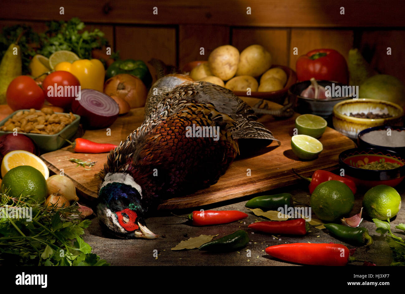 Fagiano con materie prime sul tavolo Foto Stock