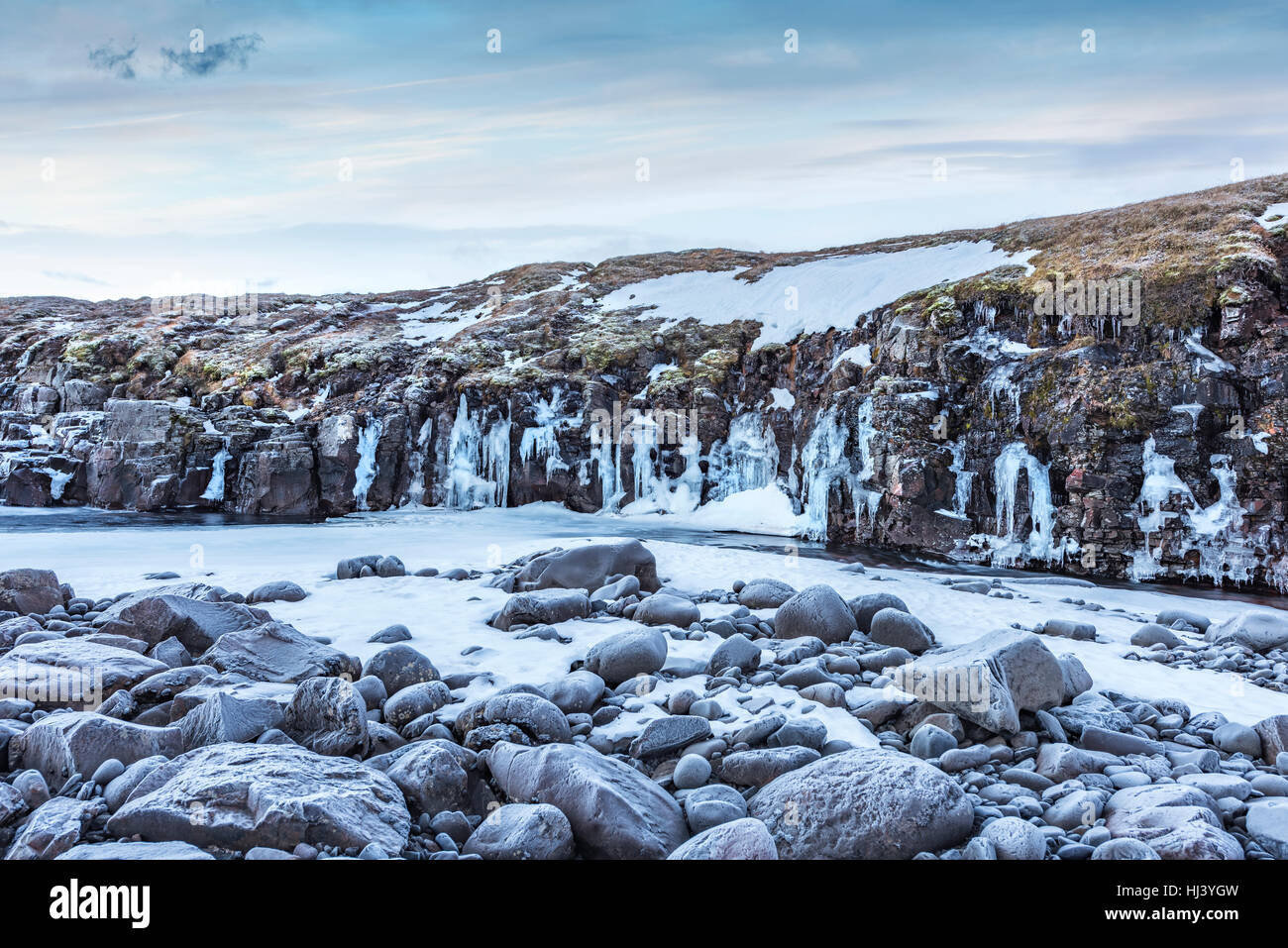 Un fiume congelato nelle Highlands di Islanda incorniciata dai cieli pastello e scoscesi offre paesaggio panoramico epitomizing congelata di deserto. Foto Stock