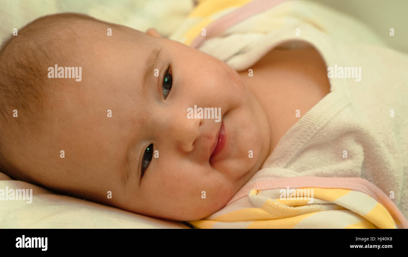 Piccolo bambino sdraiato sul letto di close-up verticale Foto Stock