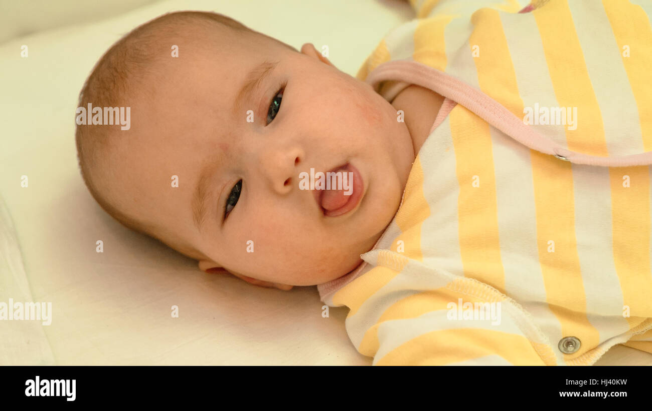 Piccolo bambino sdraiato sul letto di close-up verticale Foto Stock