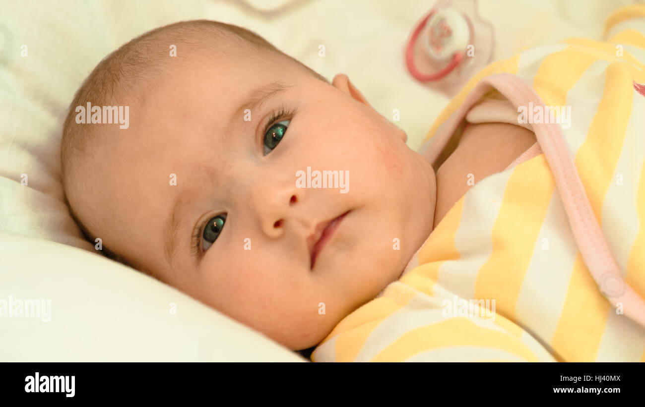 Piccolo bambino sdraiato sul letto di close-up verticale Foto Stock