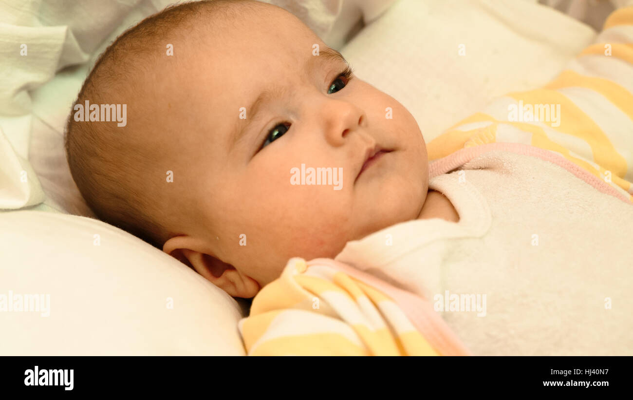 Piccolo bambino sdraiato sul letto di close-up verticale Foto Stock