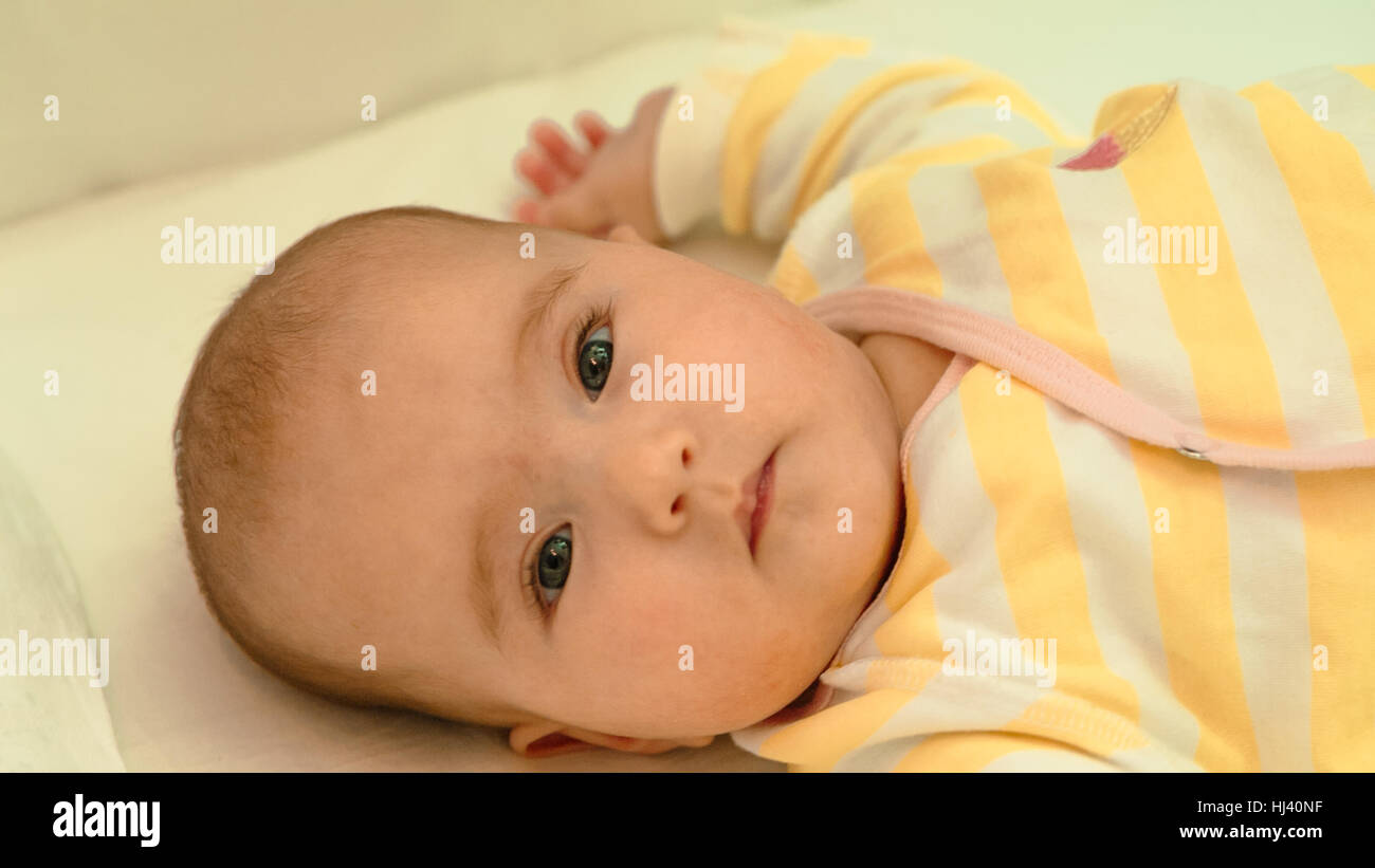 Piccolo bambino sdraiato sul letto di close-up verticale Foto Stock