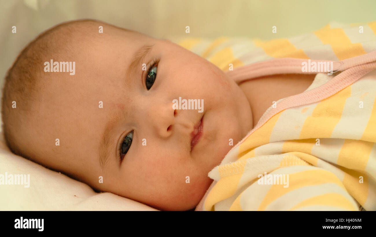 Piccolo bambino sdraiato sul letto di close-up verticale Foto Stock