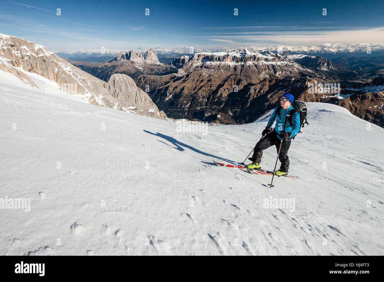 Alpinista di sci in salita a Punta Rocca, dietro Sellastock, Sassolungo e Sassopiatto, Alpi innevate, Val di Fassa Dolomiti Foto Stock